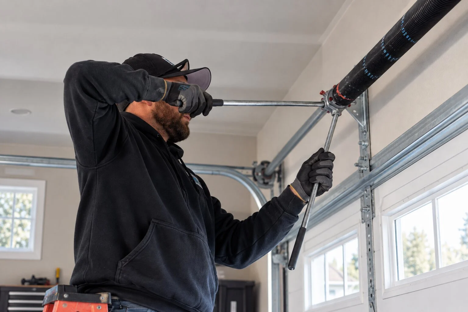Garage door torsion springs above a residential door after repair