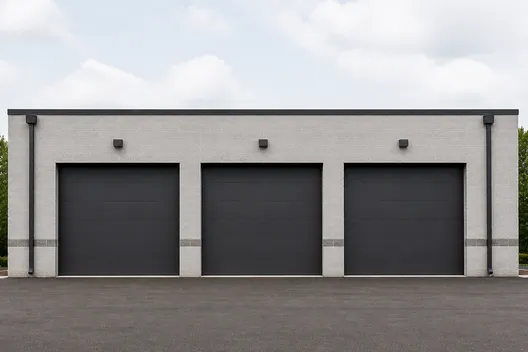 Three charcoal overhead doors on a commercial building