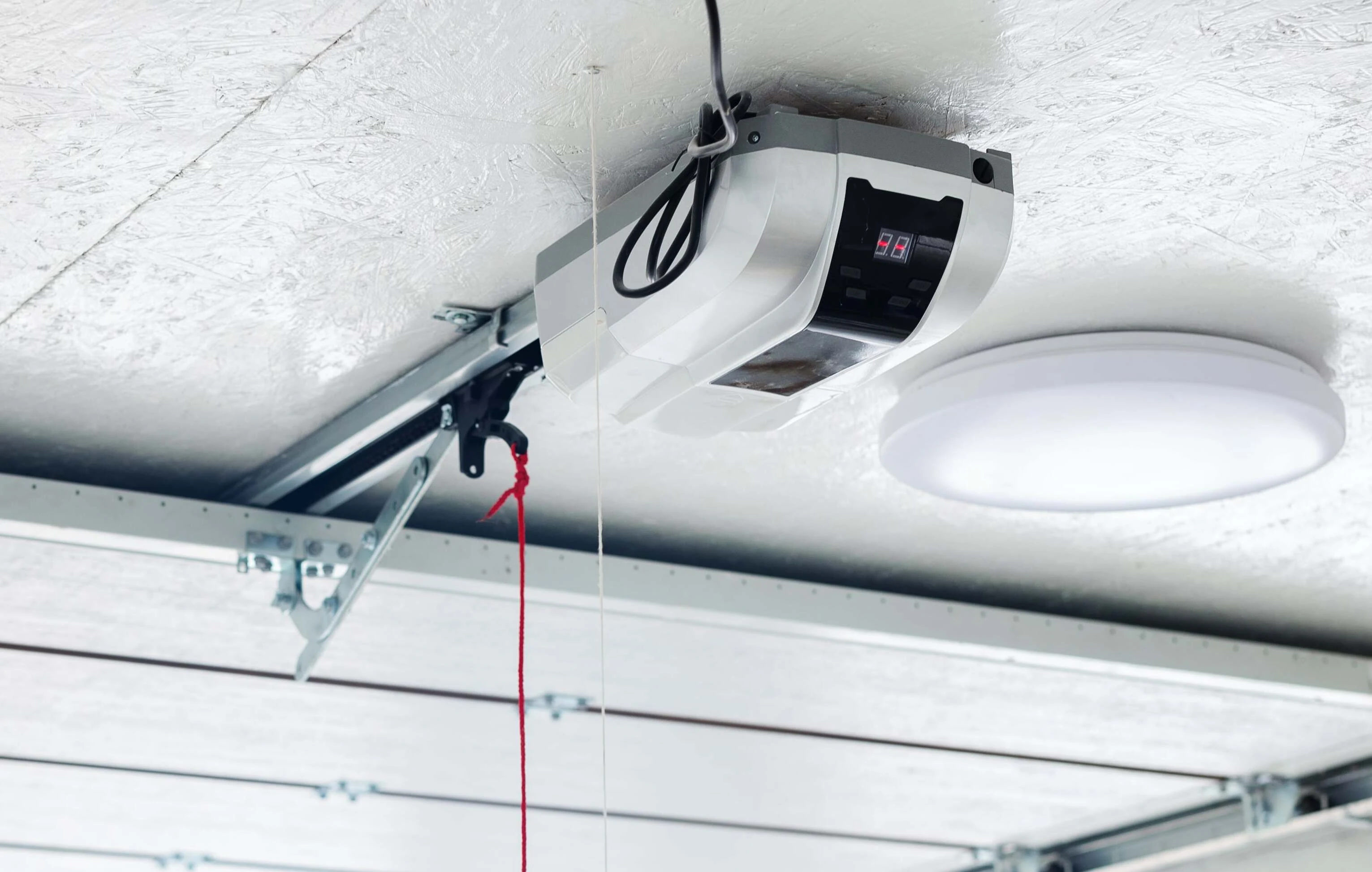 Ceiling-mounted belt-drive garage door opener and rail