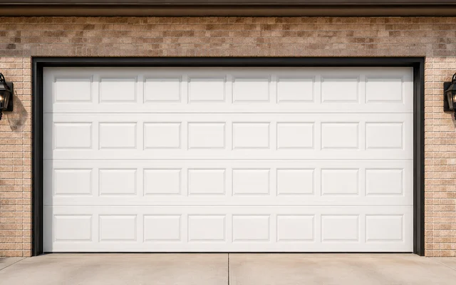 White raised-panel steel garage door on a brick home